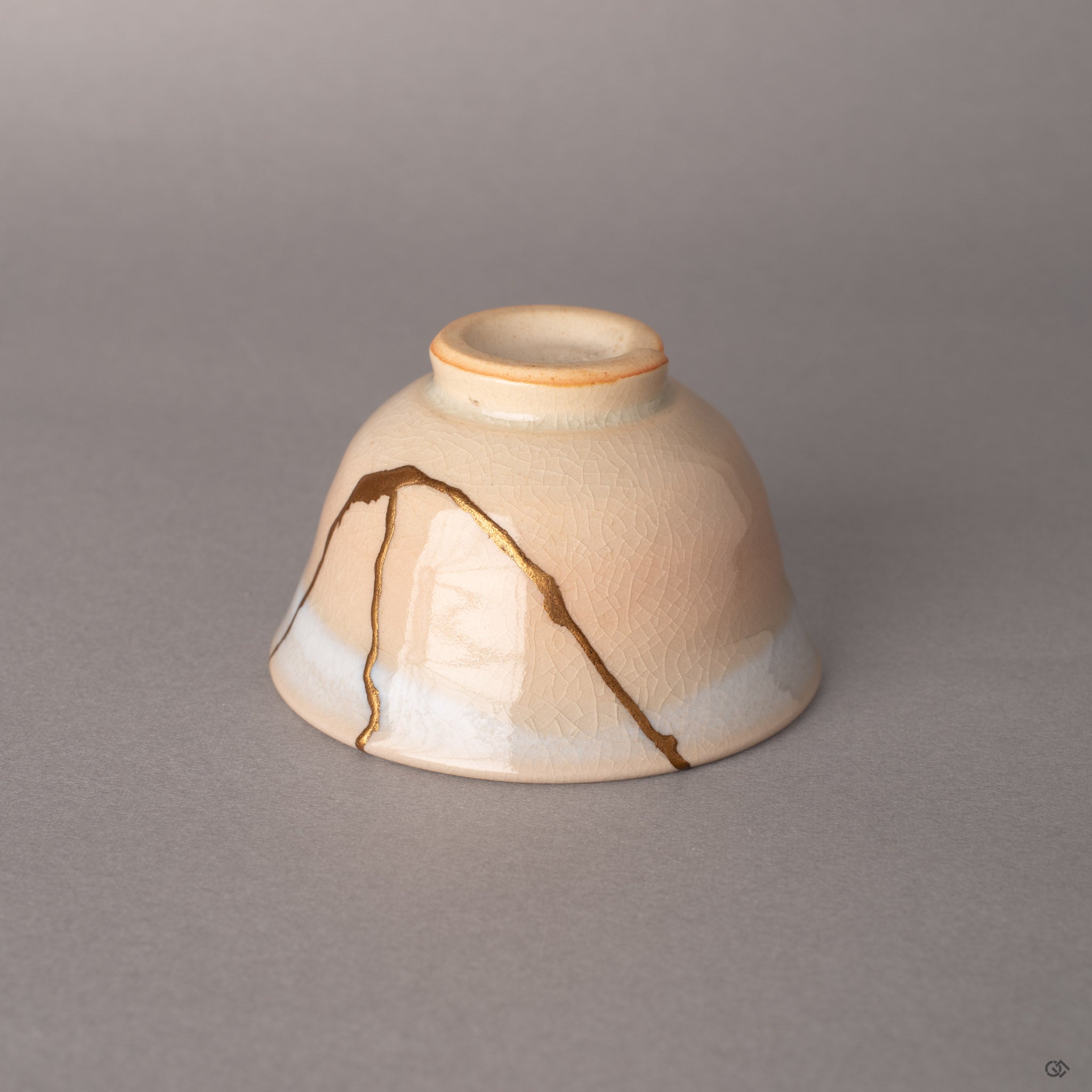 Gold kintsugi seams traverse cream-colored Hagi earthenware, each line a quiet meditation on impermanence.
