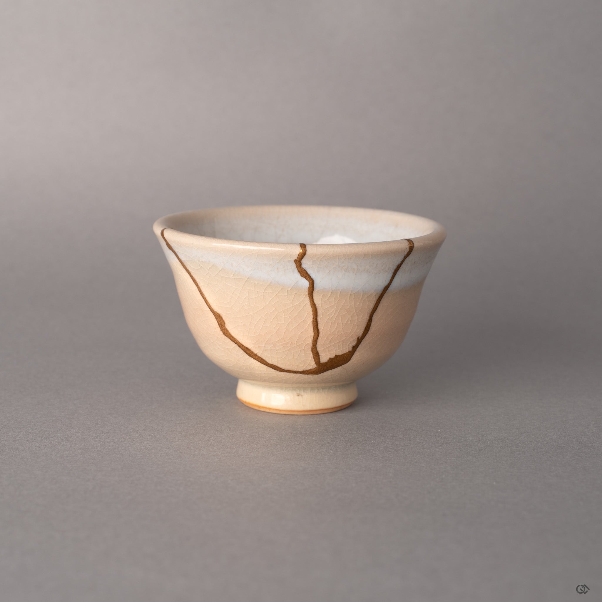 Hagi ware cup with 24K gold kintsugi seams reuniting earthenware fragments, crackled cream glaze embodying wabi-sabi.
