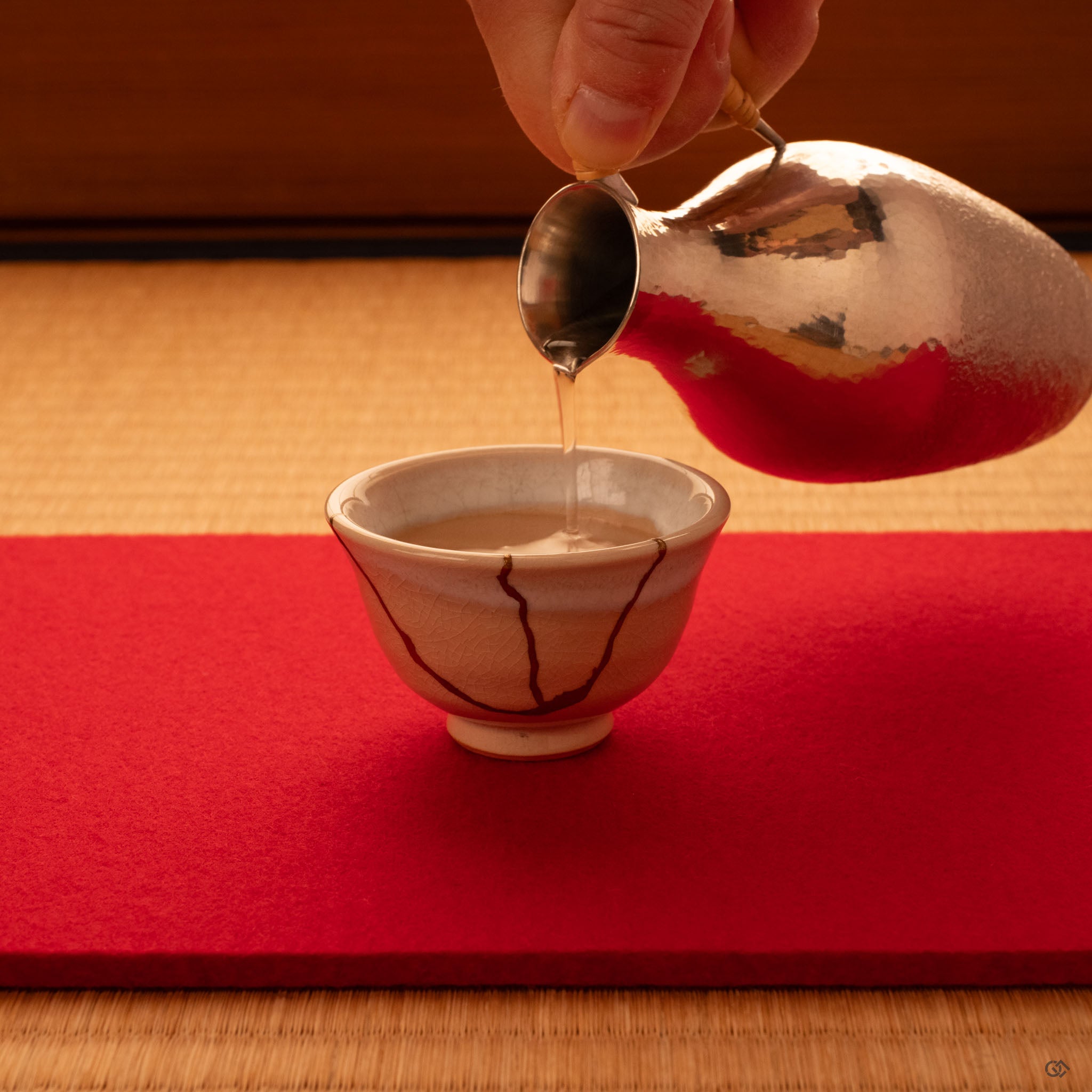 A Hagi kintsugi cup rests on tatami, gold seams glowing softly—tea ceremony heritage made present.