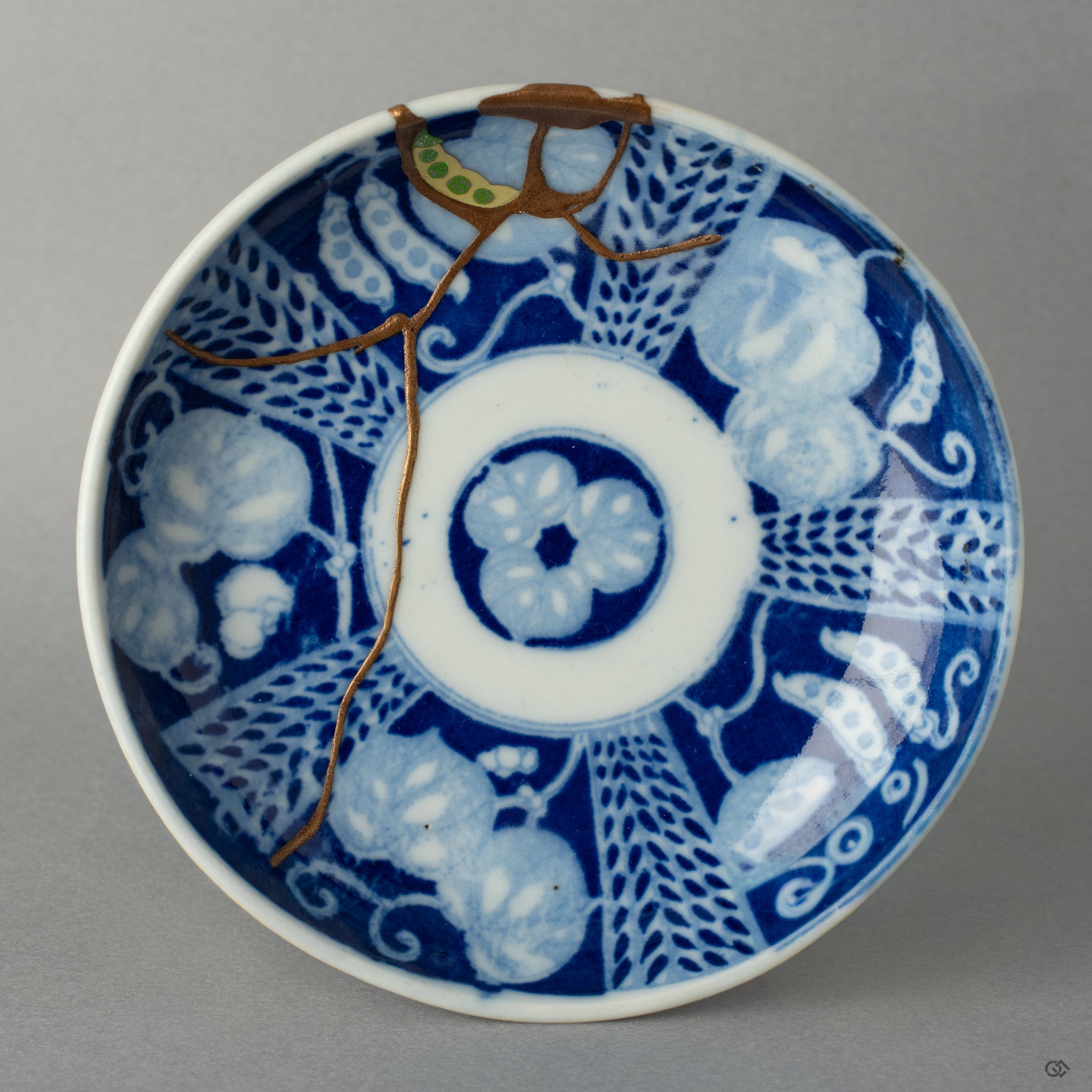 Top view of a Ko-Imari kintsugi dish, its golden seams reflecting slow craft and a philosophy of care through urushi restoration.