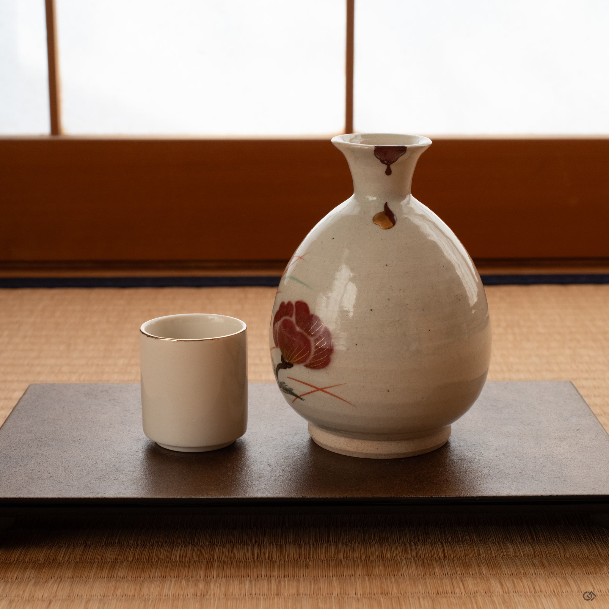 Kintsugi tokkuri on tatami, restored with vermilion lacquer and gold maki-e, evoking the quiet spirit of wabi-sabi.