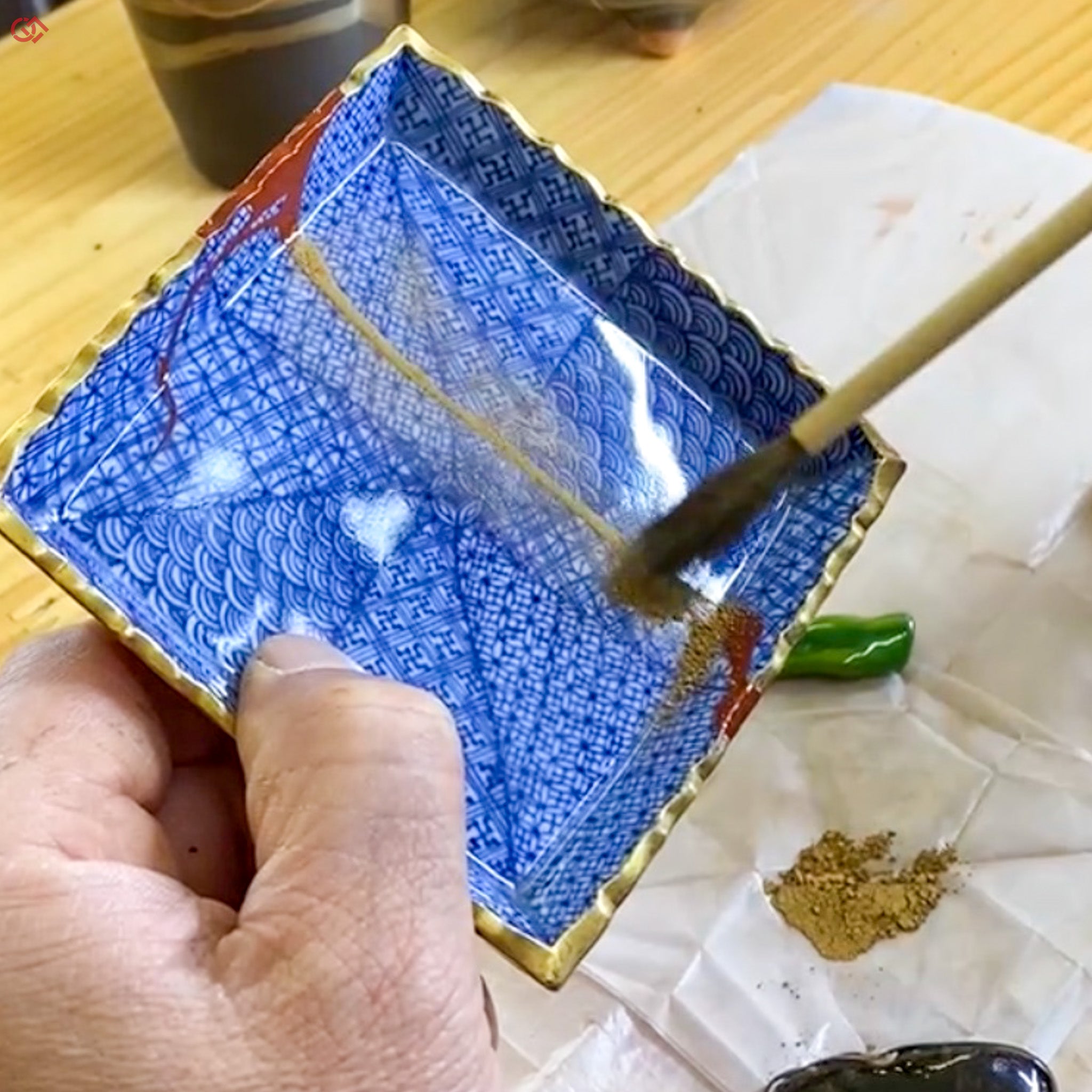 Sprinkling gold powder during traditional Kintsugi