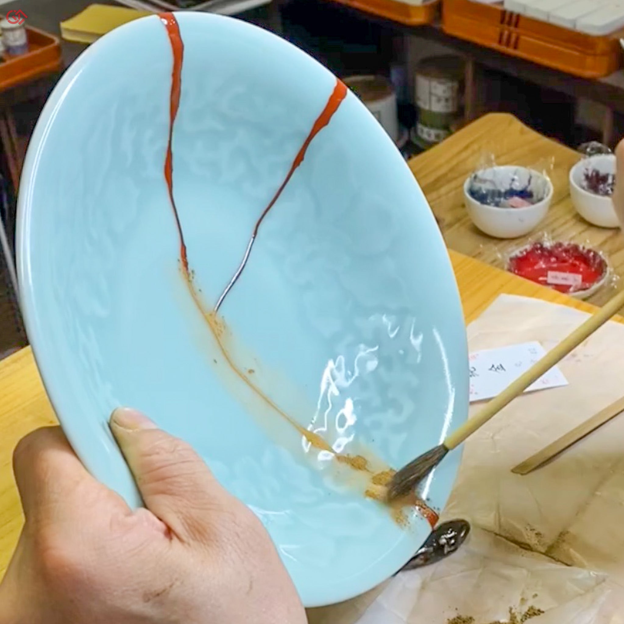 Sprinkling gold powder during traditional Kintsugi