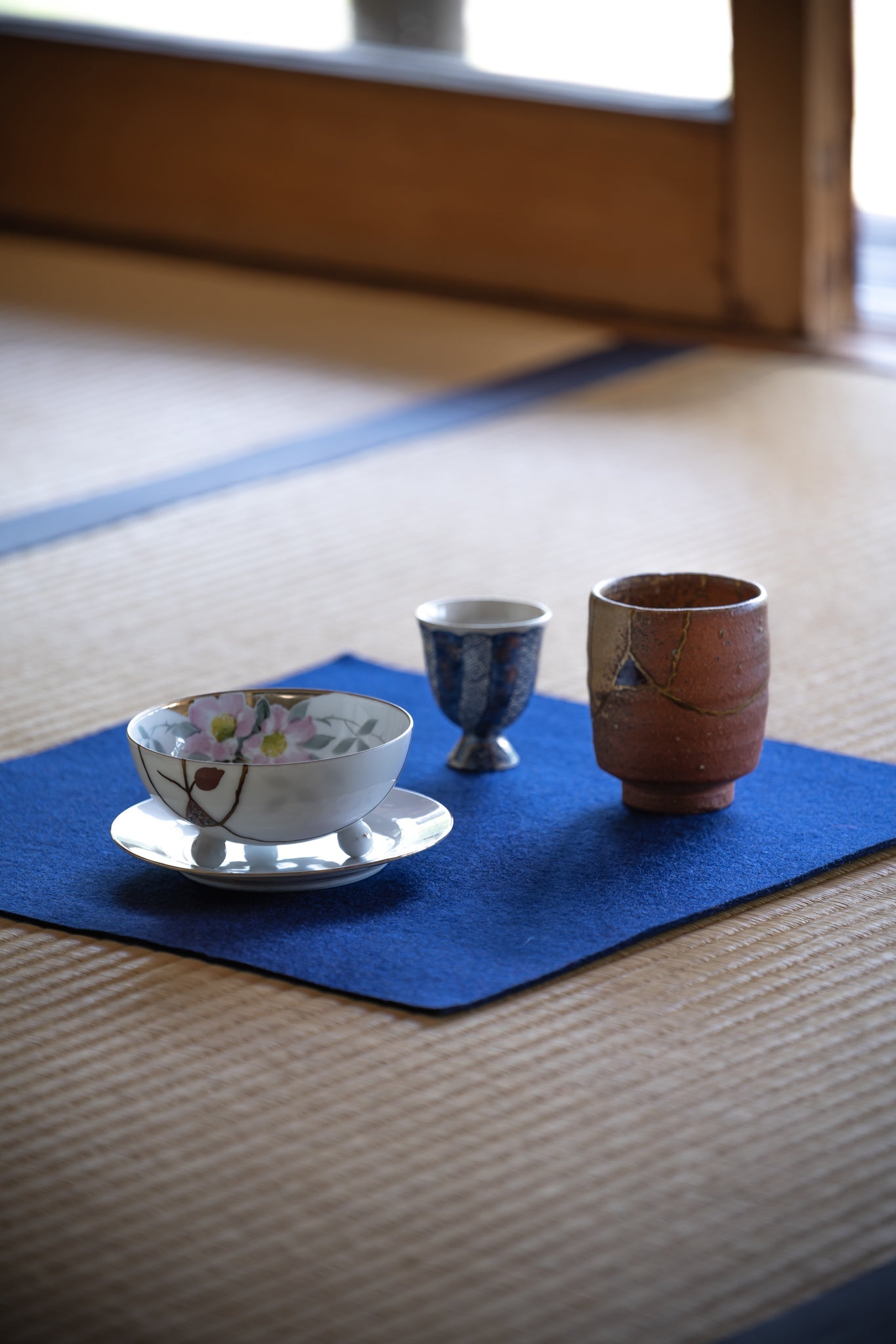A curated selection of Adorned Kintsugi artworks, showcasing advanced Japanese urushi lacquer techniques on a traditional tatami setting.