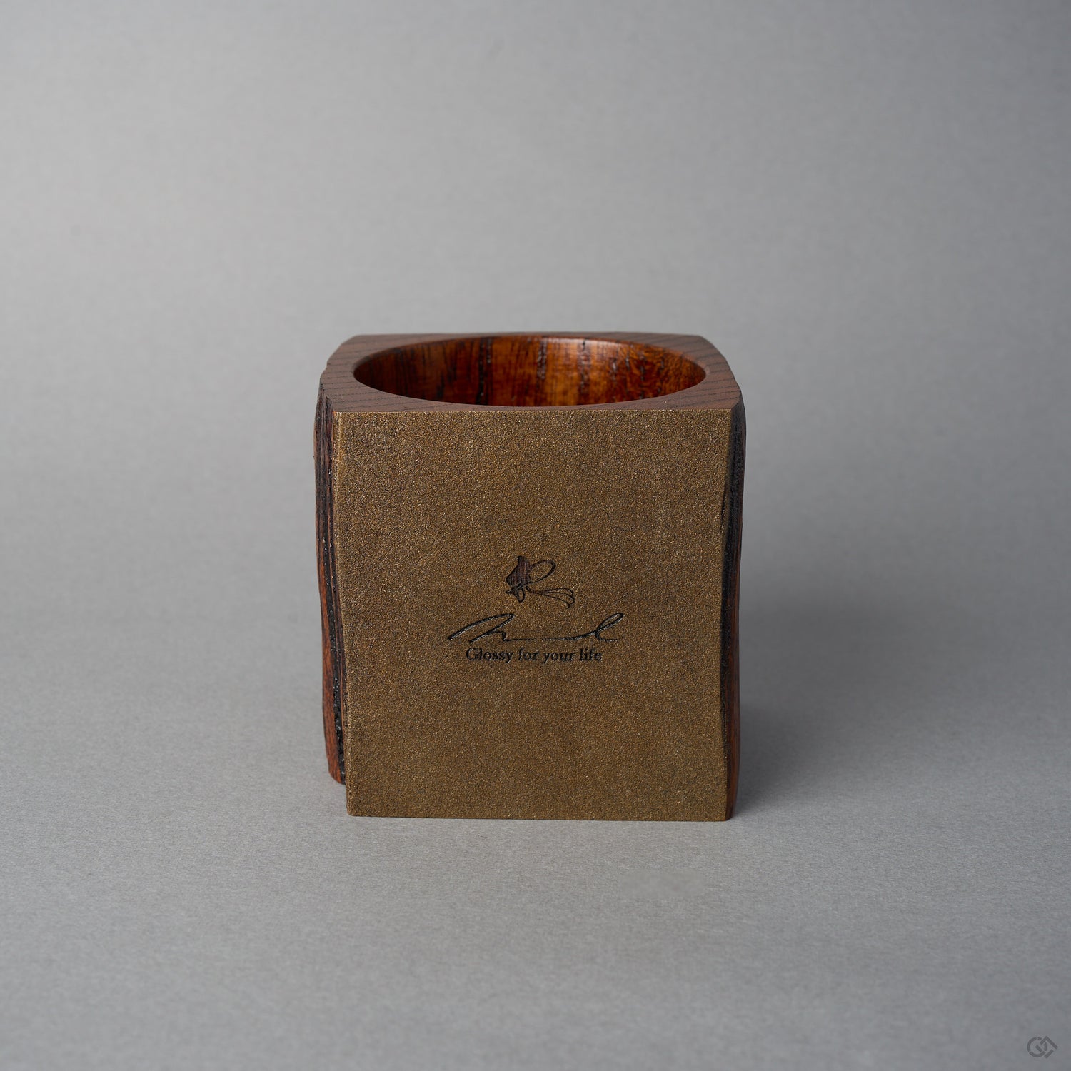 Angled front view of Nobuyasu Suginaka's KODAMA Nashiji : an aged-wood vessel whose front face is finished in metal-flecked nashiji lacquer that shimmers like bronze, bearing a maker's logo.