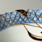 A detailed view of the rare Yobitsugi technique, where a fragment from another historic ceramic has been seamlessly integrated into the repair, showcasing the master's profound knowledge and skill.
