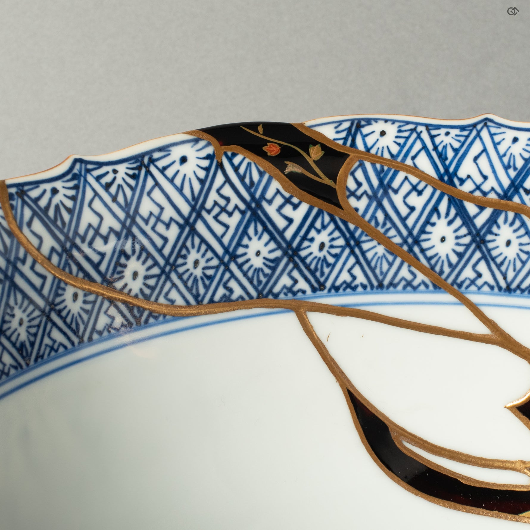 A detailed view of the rare Yobitsugi technique, where a fragment from another historic ceramic has been seamlessly integrated into the repair, showcasing the master's profound knowledge and skill.
