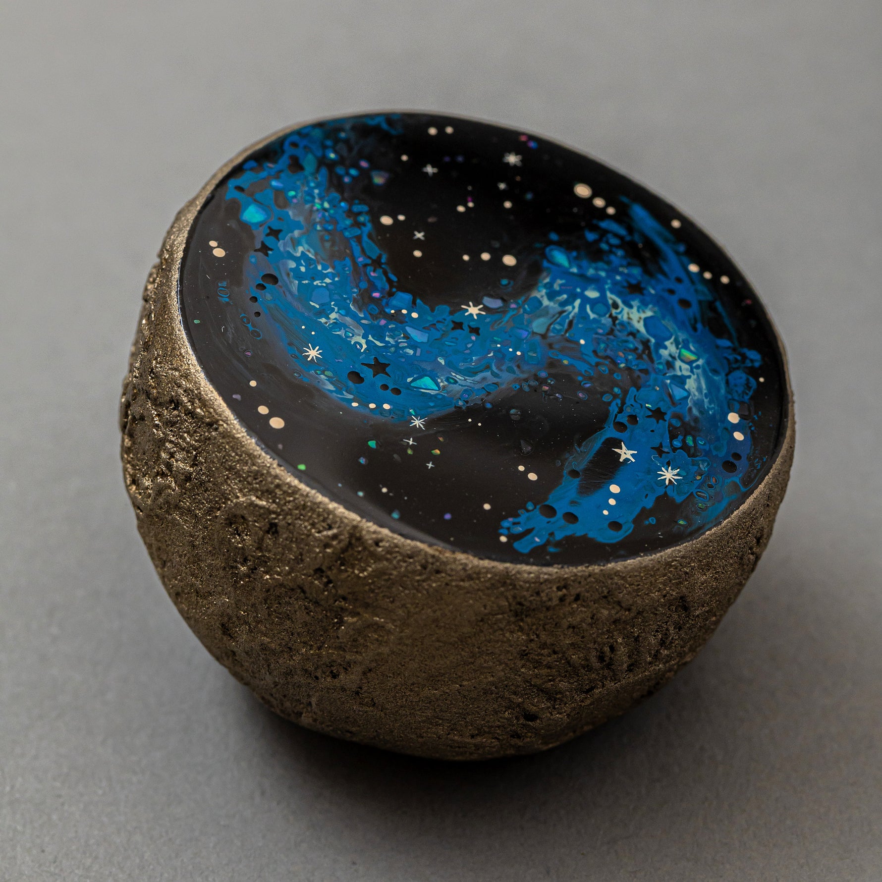 Top view of Union of Skies by Keiko Hata, showing the oval lacquer dome encircled by a gilded band, like a planet within a ring.
