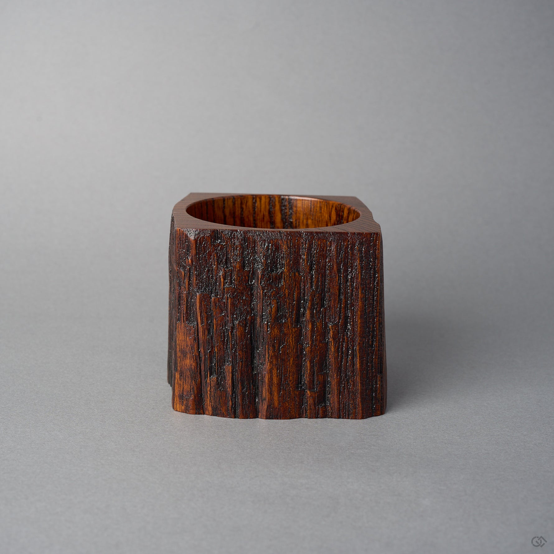 Back view of KODAMA Black Roiro by Nobuyasu Suginaka, showing the rough vertical grain and weathered bark texture of the century-old wood and its carved foot.