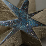 Macro detail of the blue urushi center of Kiraboshi / Hakugin, where raden flecks and tin powder sparkle like scattered stars against the dark lacquer.