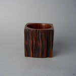 Side view of KODAMA Nashiji, where the dark reddish grain and craggy surface of the aged wood wrap around the carved vessel.