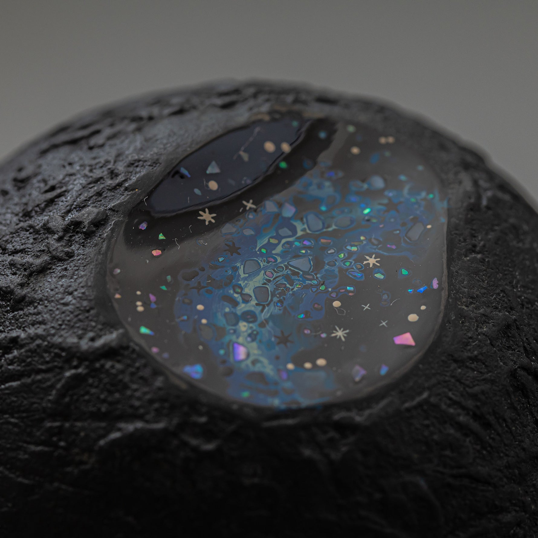 Close view of the carved, cratered gold-leaf surface of Amamitsuki beside its star-filled blue raden window, revealing the layered urushi texture.