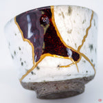 Close-up photo of an authentic Kintsugi pottery piece, showing the detail of its repairs and craftsmanship