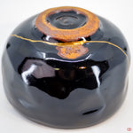 Close-up photo of an authentic Kintsugi pottery piece, showing the detail of its repairs and craftsmanship