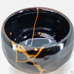 Close-up photo of an authentic Kintsugi pottery piece, showing the detail of its repairs and craftsmanship
