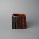 Another side view of KODAMA Black Roiro, showing a natural split in the craggy wood surface running down the body of the vessel.