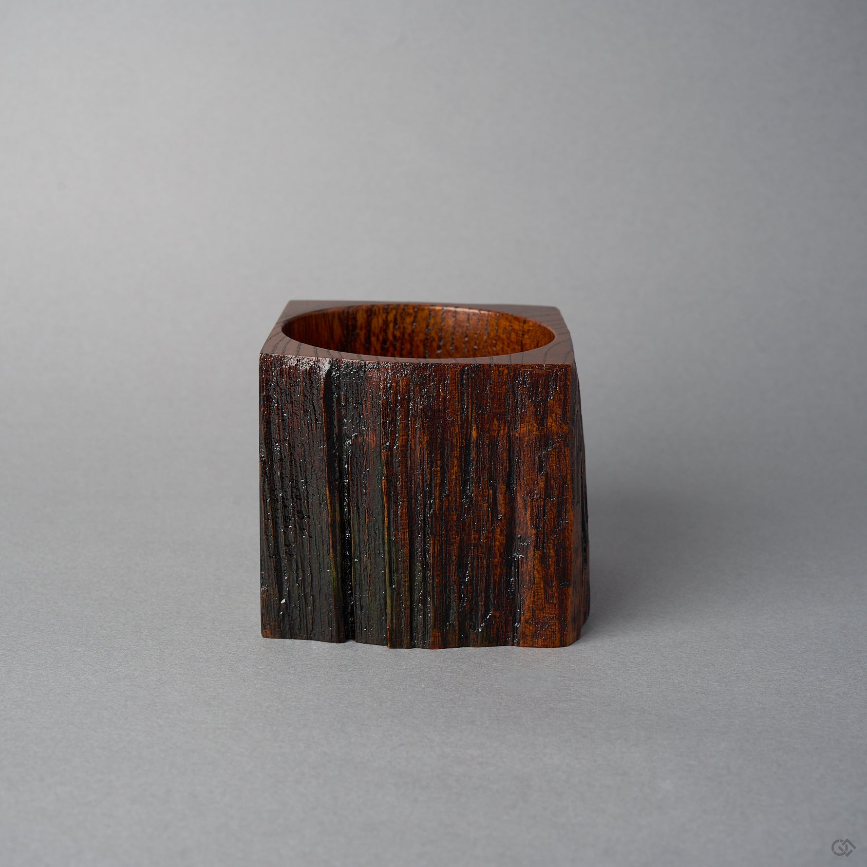 Another side view of KODAMA Black Roiro, showing a natural split in the craggy wood surface running down the body of the vessel.