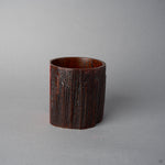 Another side view of KODAMA Red Roiro, showing the edge where the rough aged wood meets the smooth crimson lacquer panel.