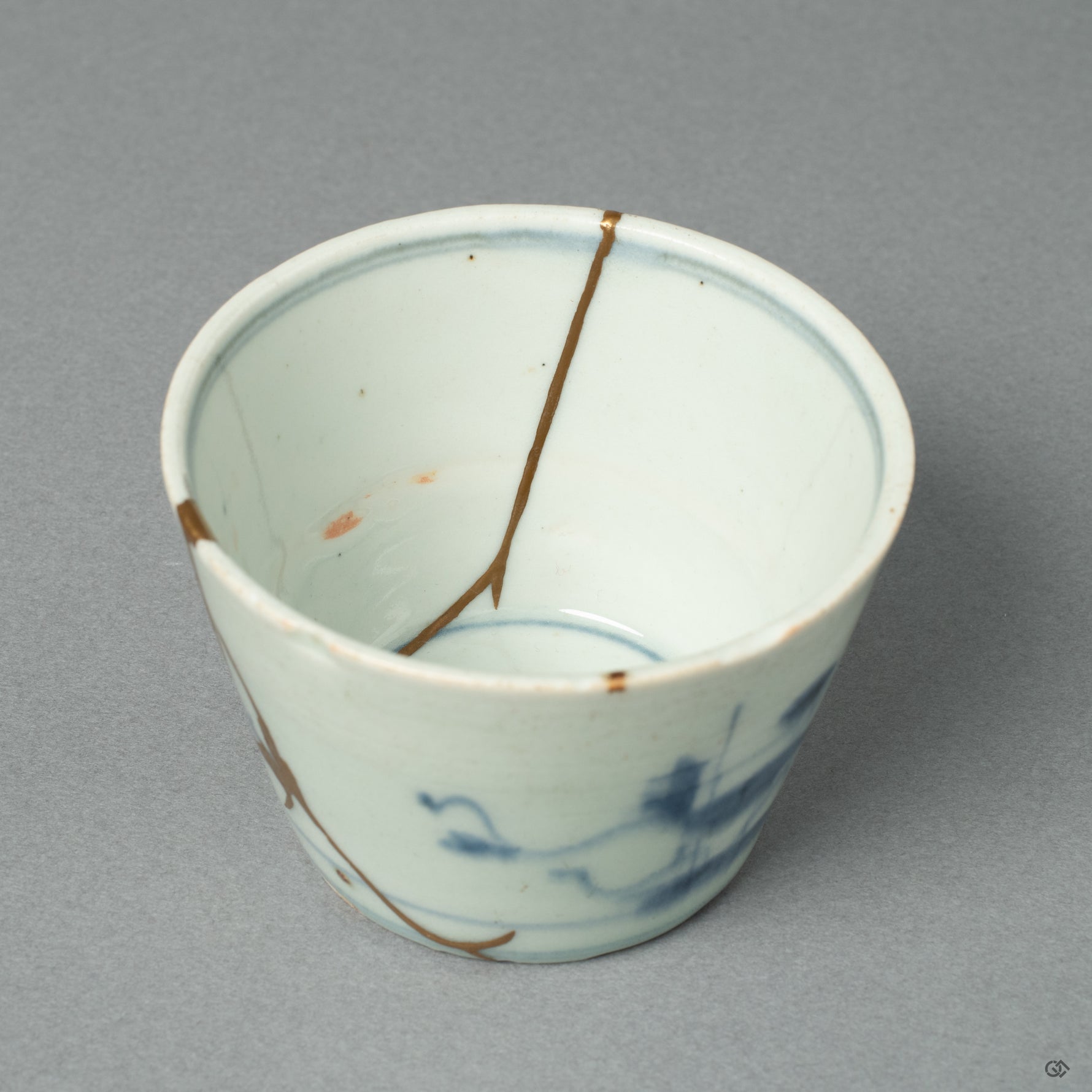 This macro view shows a luminous 24k gold seam, a line of light that brings a new chapter to this Edo-period ochoko's long and storied life.