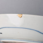 Close-up of a small chip on the outer rim of a Ko-Imari bowl, restored with natural urushi kintsugi and finished in softly lustrous 24K gold.