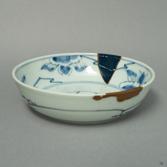 A front view of a Ko-Imari ware bowl, where lines of 24k gold and iridescent Raden inlay create a celestial dialogue on the porcelain canvas.