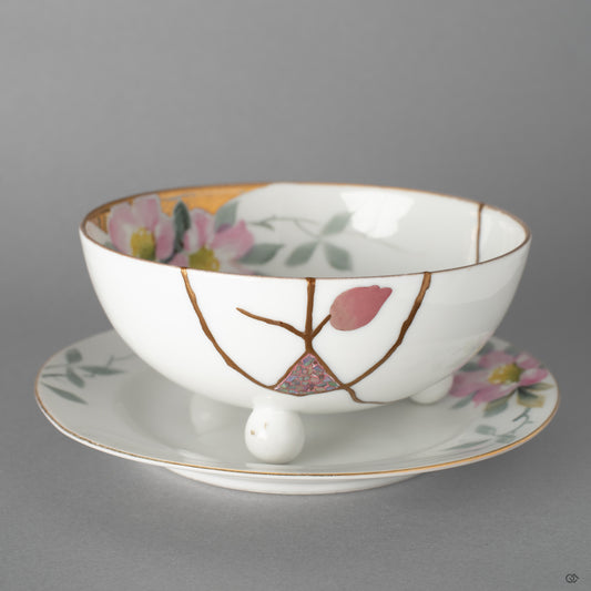 Front view of an Early Noritake cup and saucer restored with 24K gold, urushi-e, and raden, beginning a new story to tell for this heirloom.