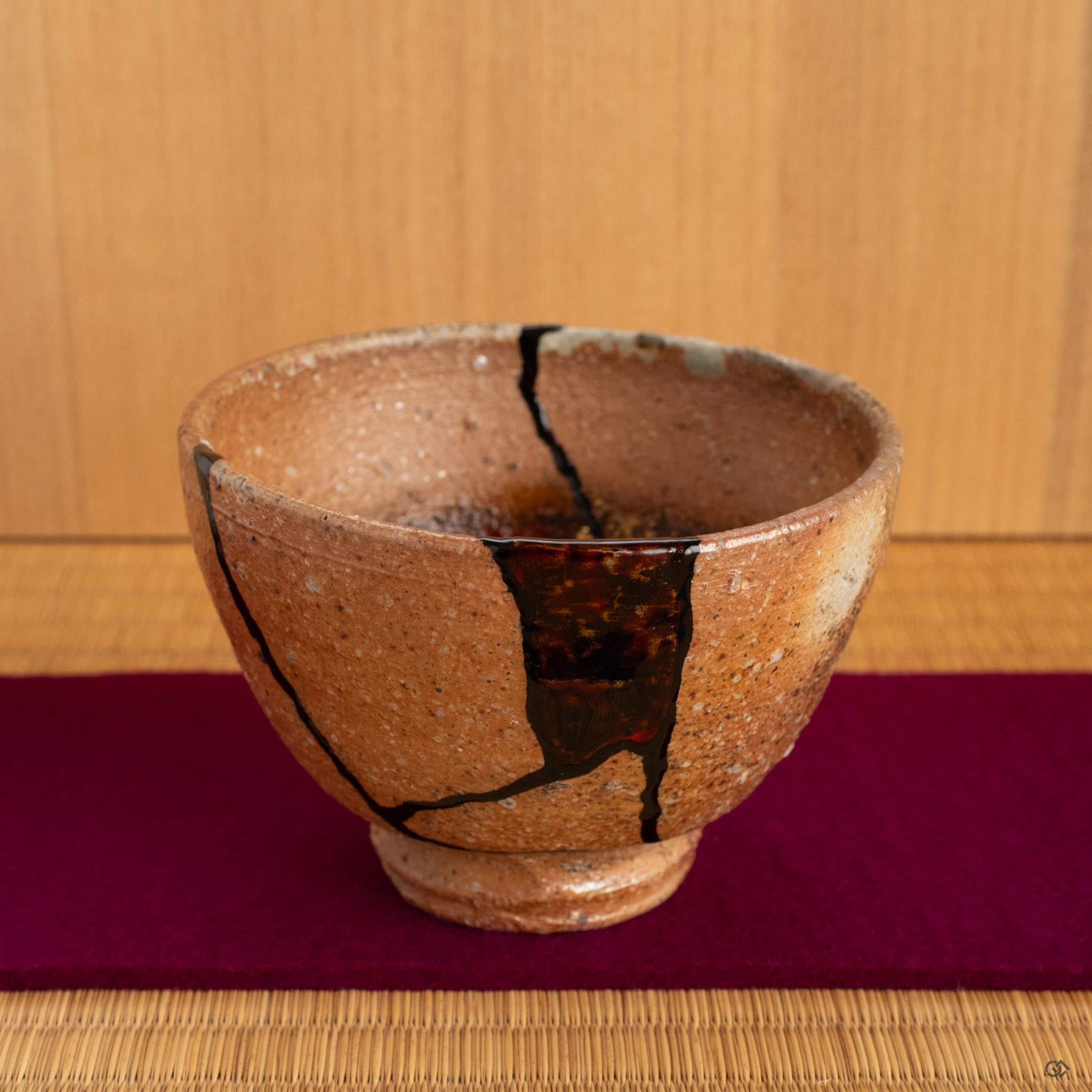 The unique mixed-media kintsugi cup put on the tatami, offering a moment of connection with its complex past and renewed, artistic present.