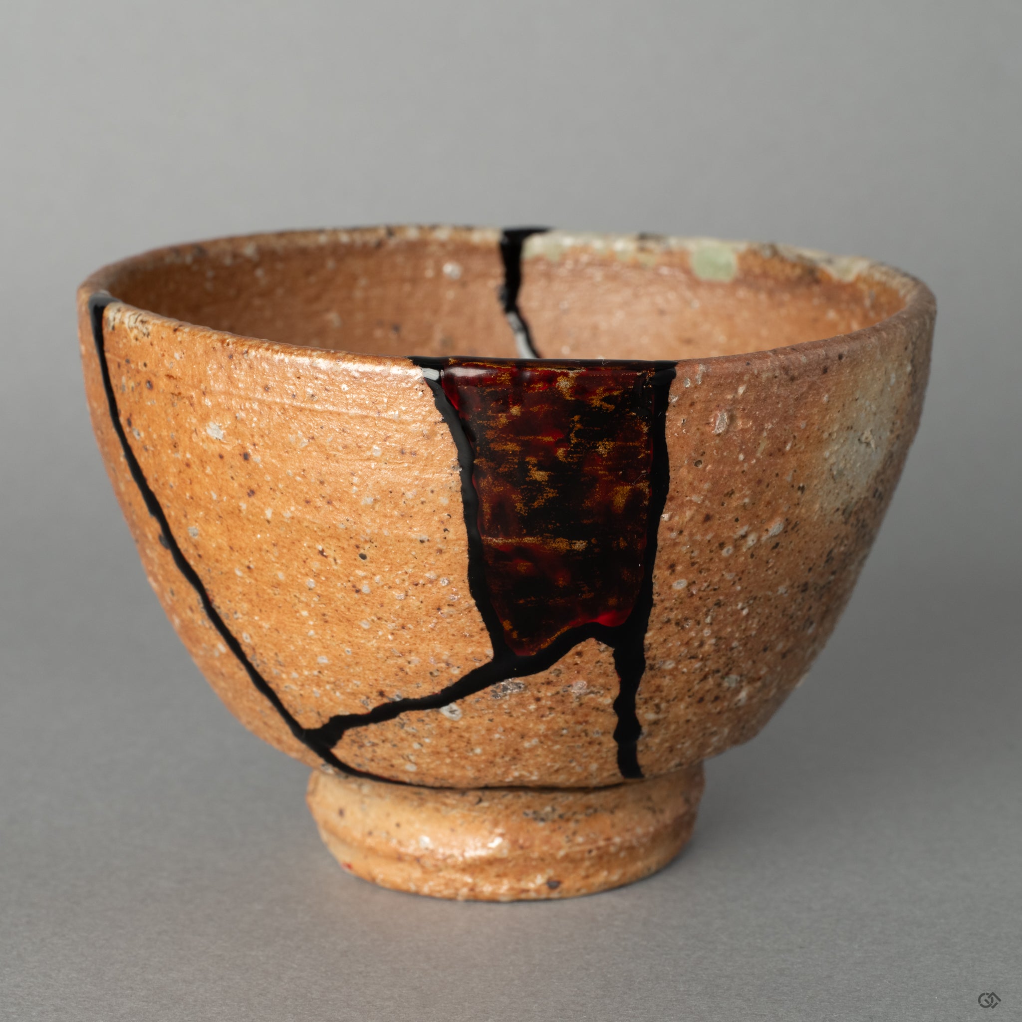 Front view of a Shigaraki cup, transformed by mixed-media kintsugi and kawarinuri lacquer, an act of rich cultural storytelling.