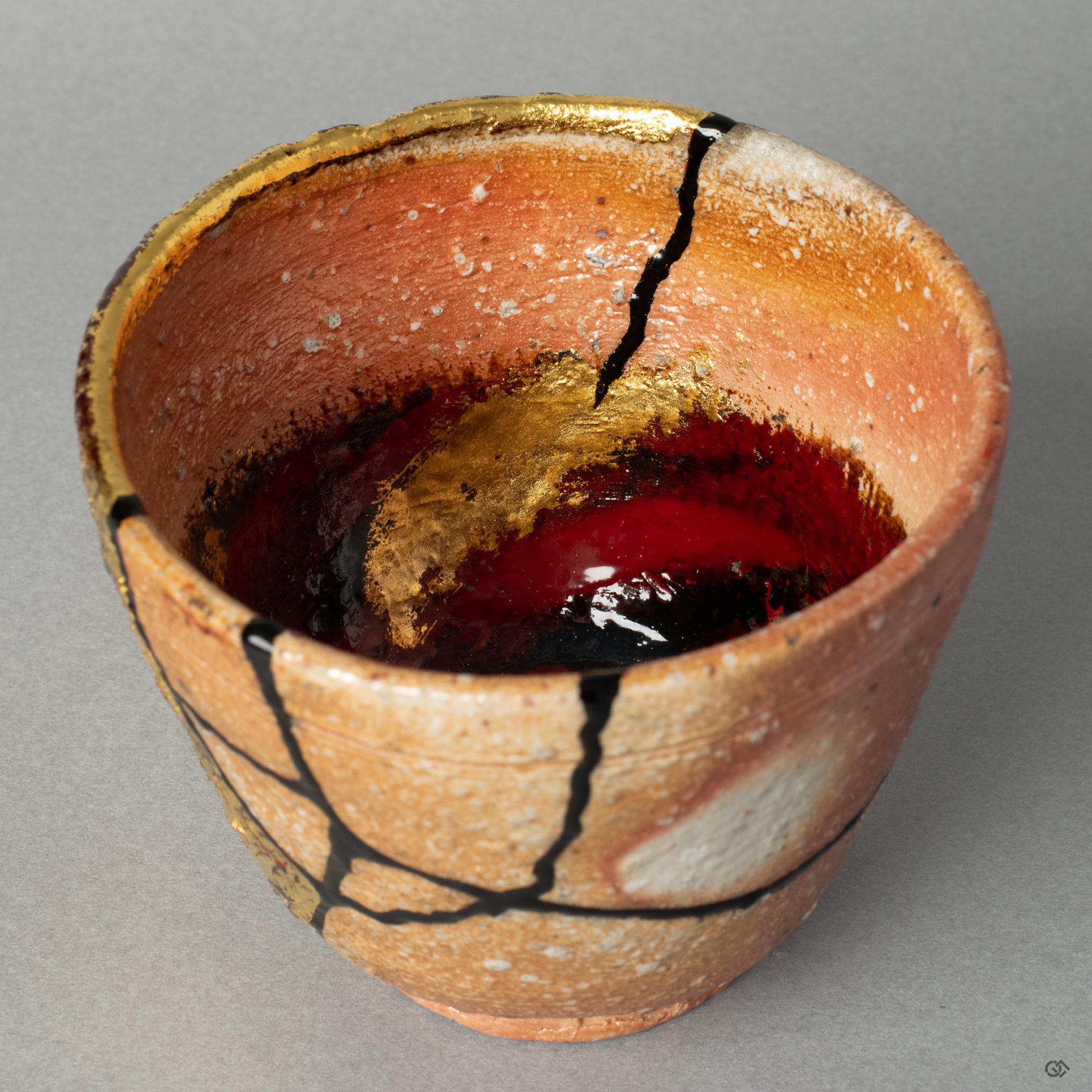 The dramatic intersection of gold leaf and colored lacquer on the rustic clay, a powerful micro-story of the journey from broken to beautiful.
