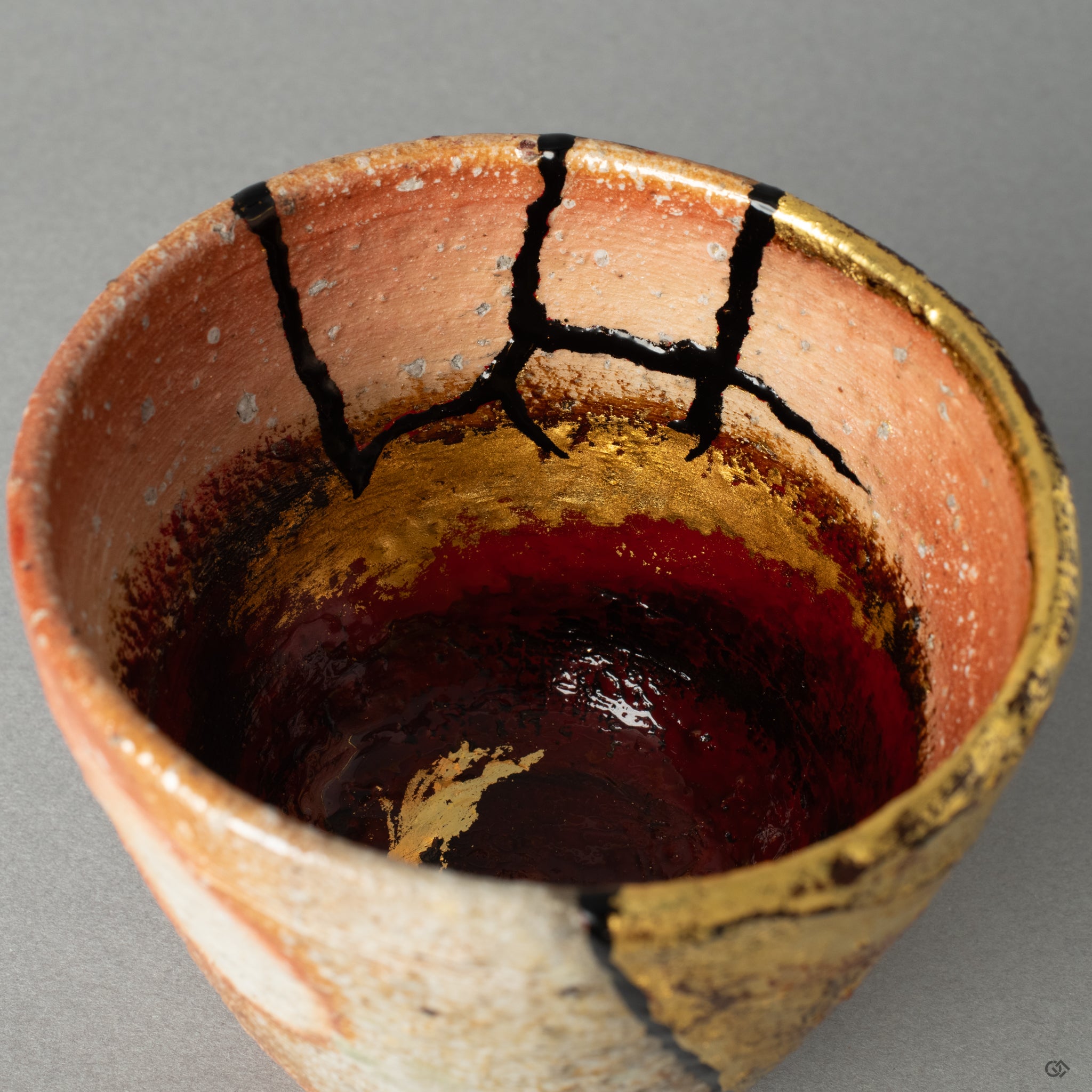 A macro photograph detailing the intersection of a shimmering gold kintsugi line with the rustic, grainy texture of the Shigaraki pottery.