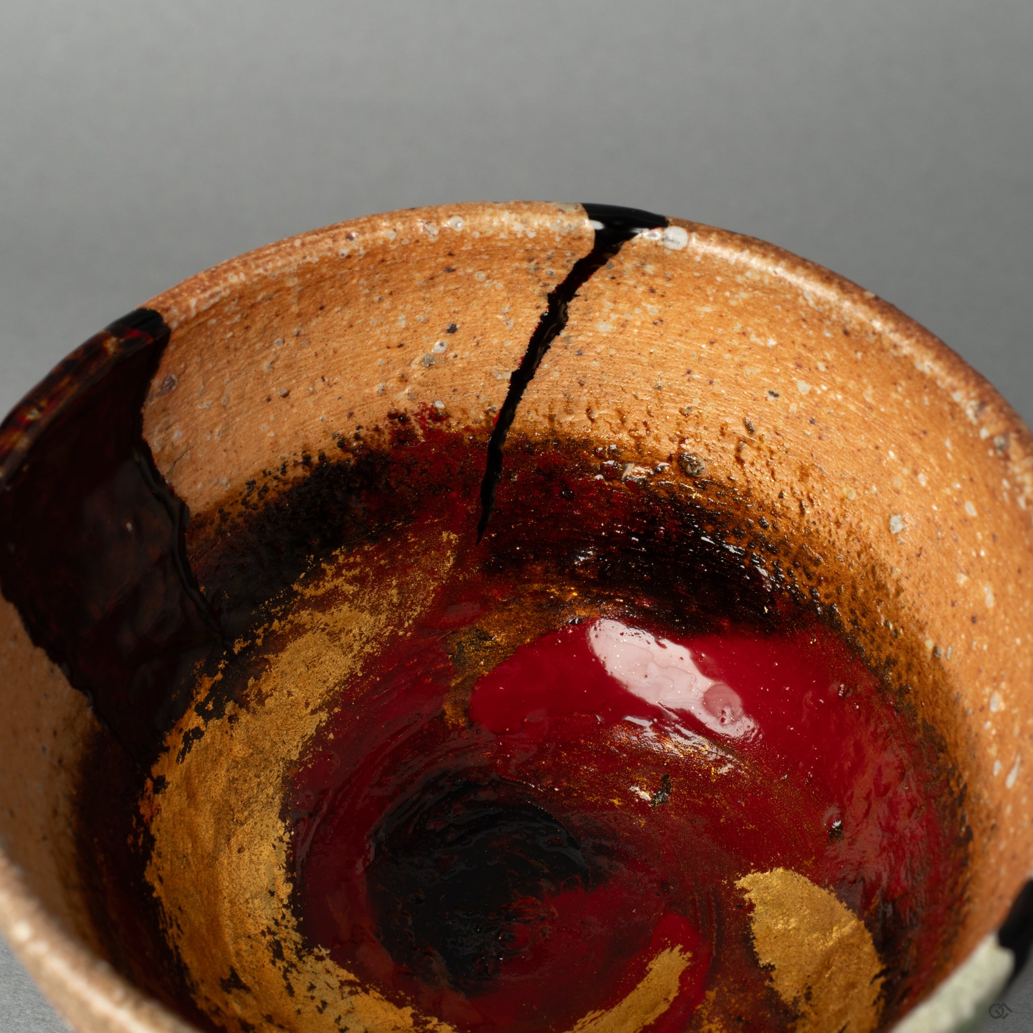 The abstract and expressive repair on the Shigaraki cup, a beautiful example of healing through art that transcends traditional mending.