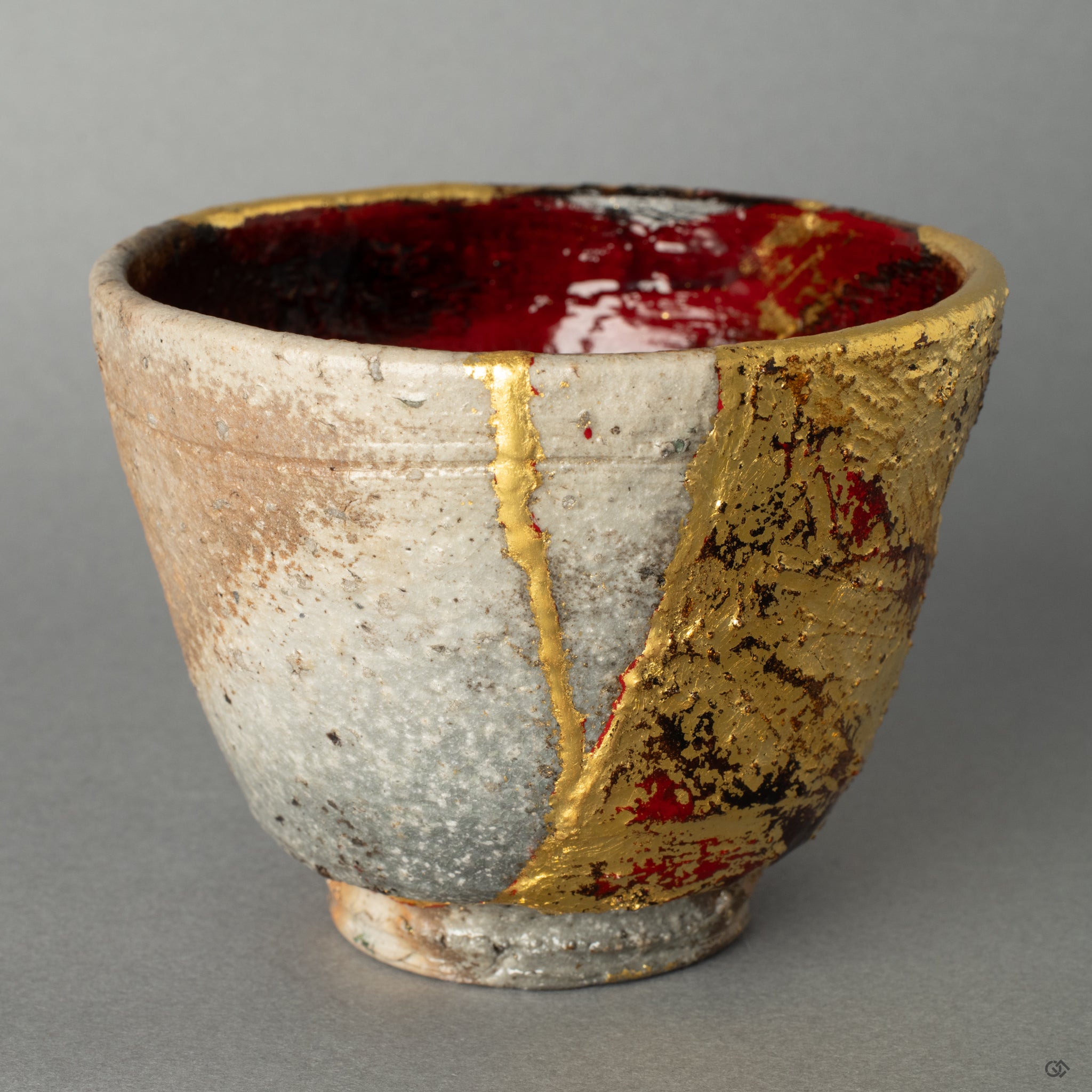 A close-up of the gold leaf repair meeting the coarse Shigaraki clay, creating a tactile history that speaks of the cups journey and renewal.