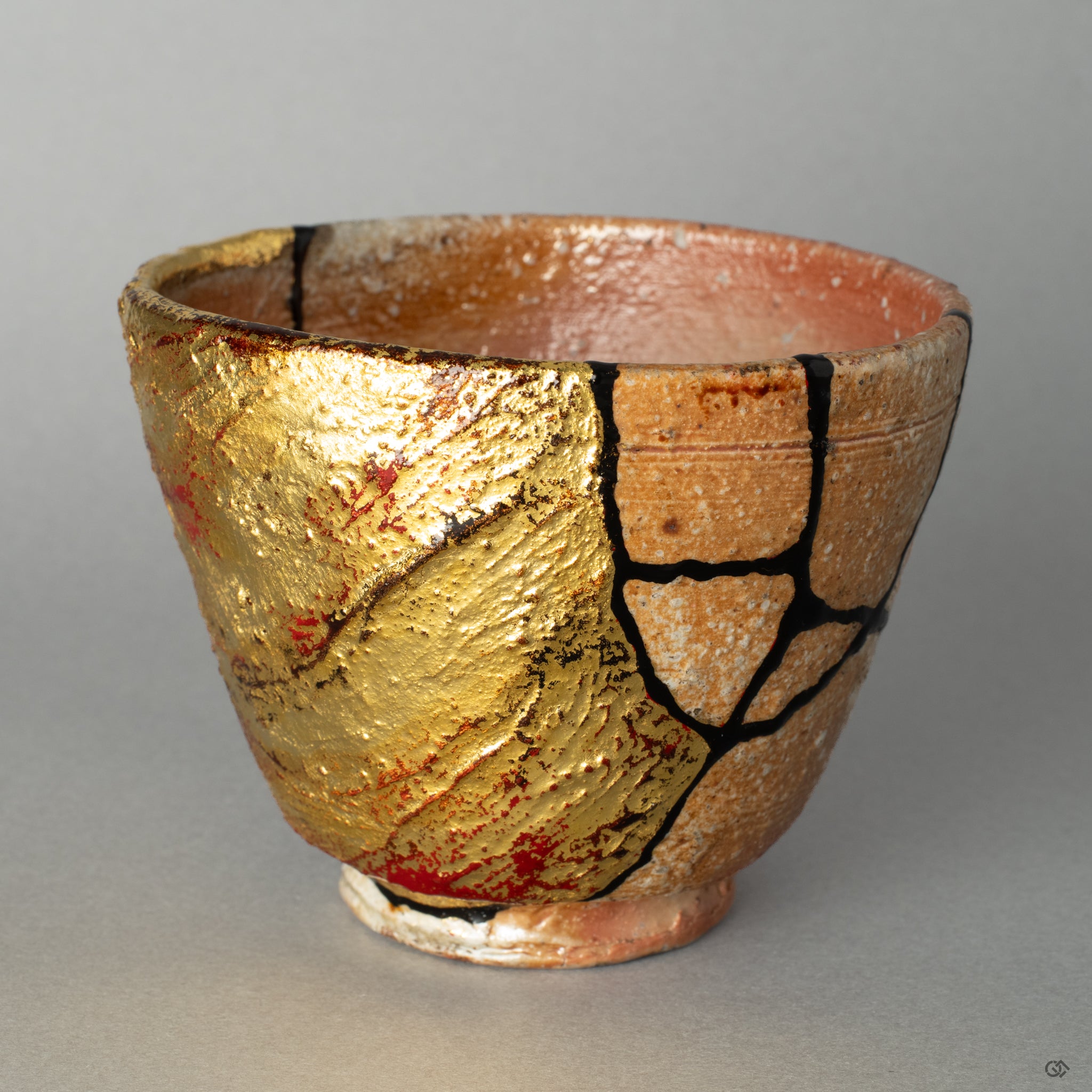 Front view of a rustic Shigaraki ware cup, artistically restored with mixed-media kintsugi, a profound expression of Japanese wabi-sabi.