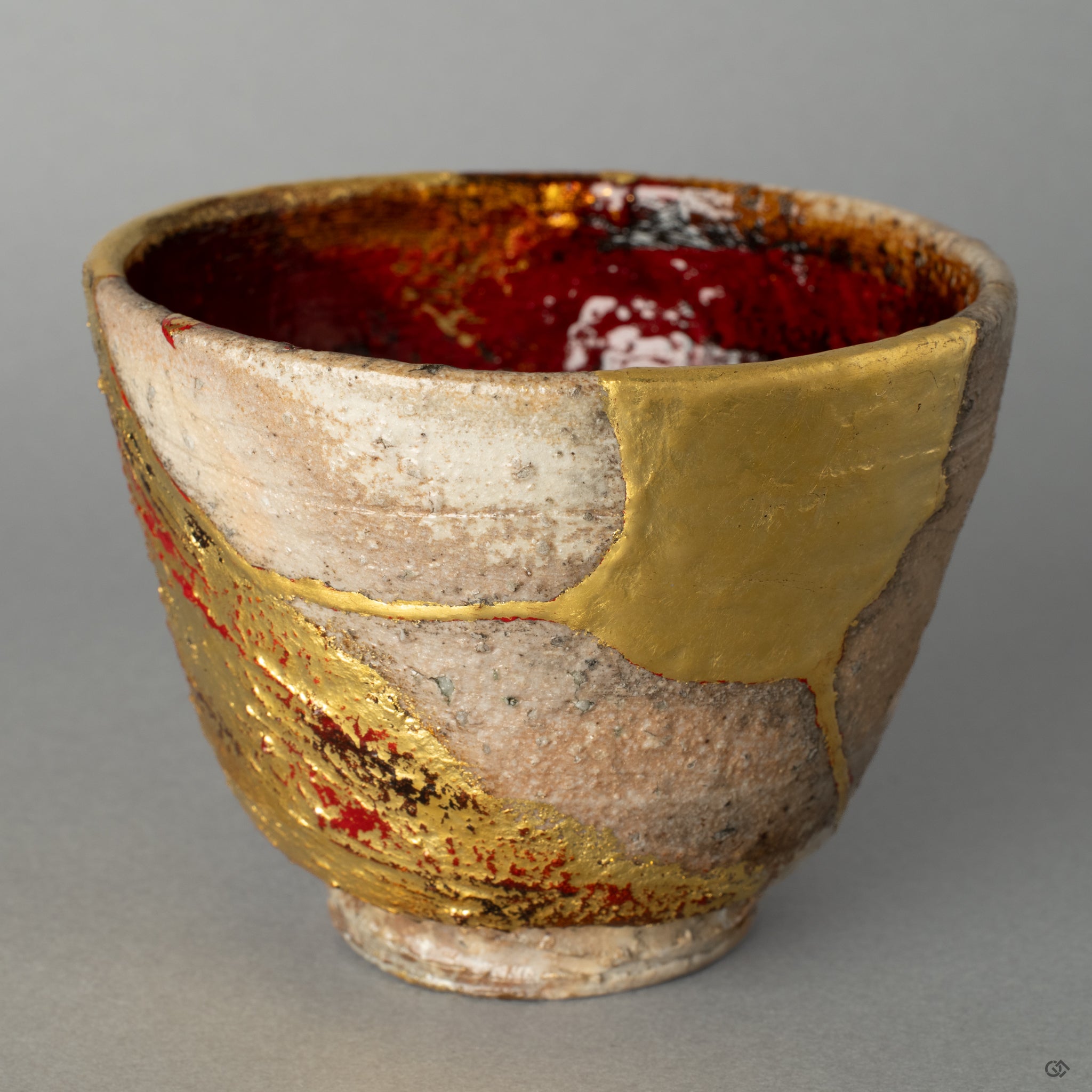 Front view of a rustic Shigaraki ware kintsugi cup, artistically restored with gold leaf and yakitsuke-urushi, a humble embodiment of Japanese wabi-sabi.
