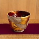 A rustic Shigaraki kintsugi cup held gently, its warmth and renewed form making it a truly soulful object for a quiet moment of tea.