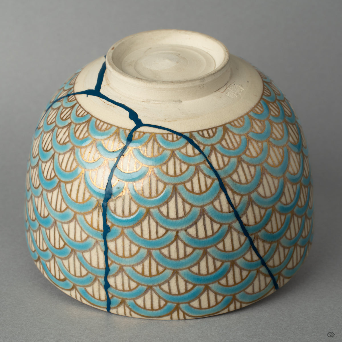 The rich texture of the kintsugi repairs made visible, a tactile history of the bowls journey, transformed by the artists hand.