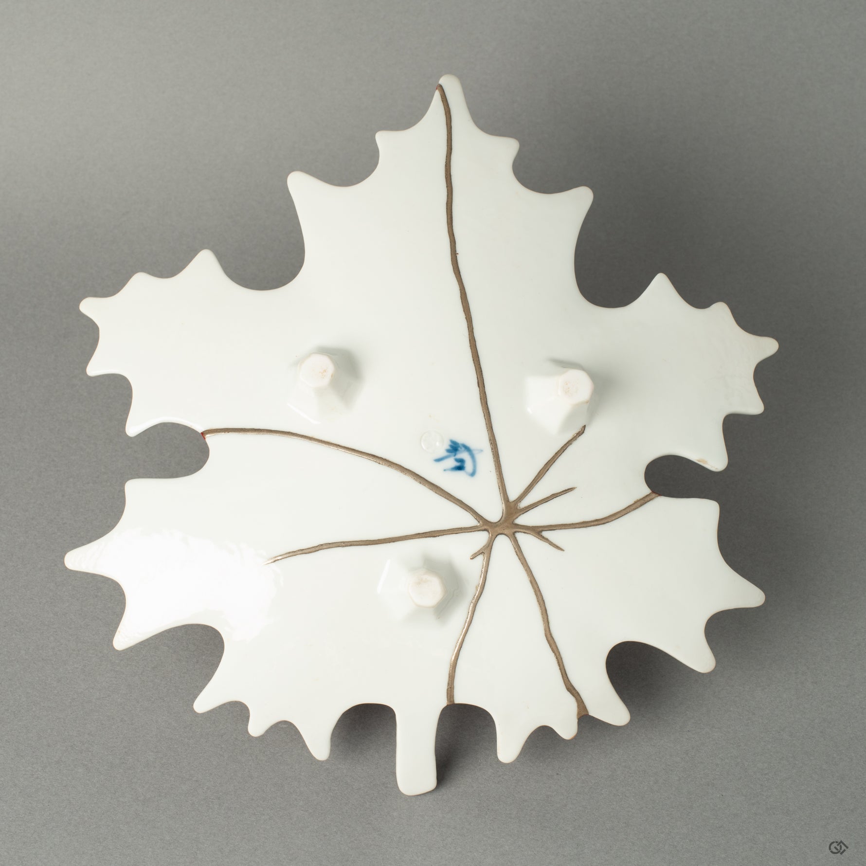 The reverse side of the Arita ware maple leaf dish, revealing a delicate network of pure silver Kintsugi lines. This hidden beauty offers a striking contrast to the vermillion top, showcasing the multifaceted nature of this unique artwork.
