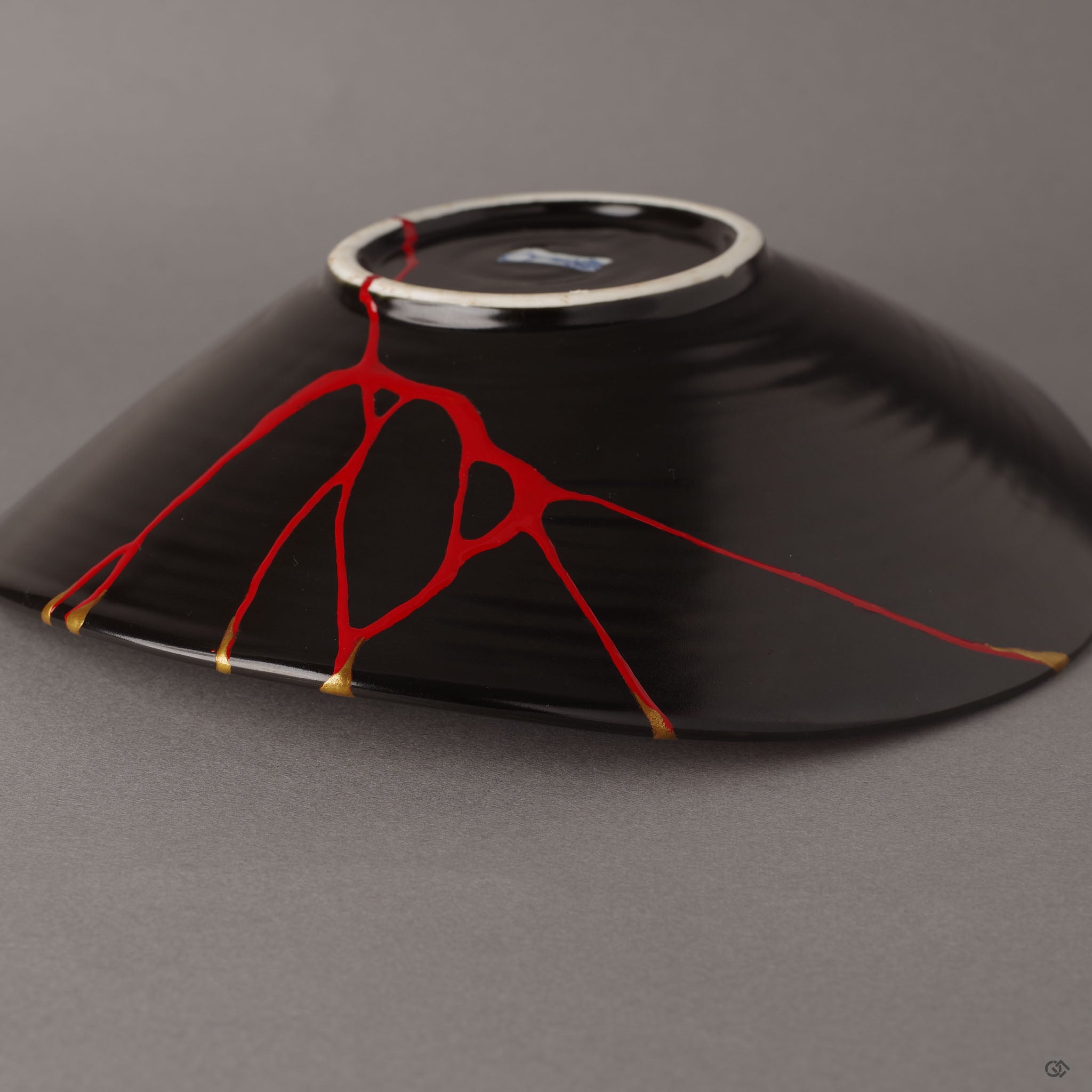 A macro view of the crimson lacquer seam on the bowl's underside, where the artisan's hand reveals the quiet beauty of iro-urushitsugi—a hidden dialogue between break and renewal.