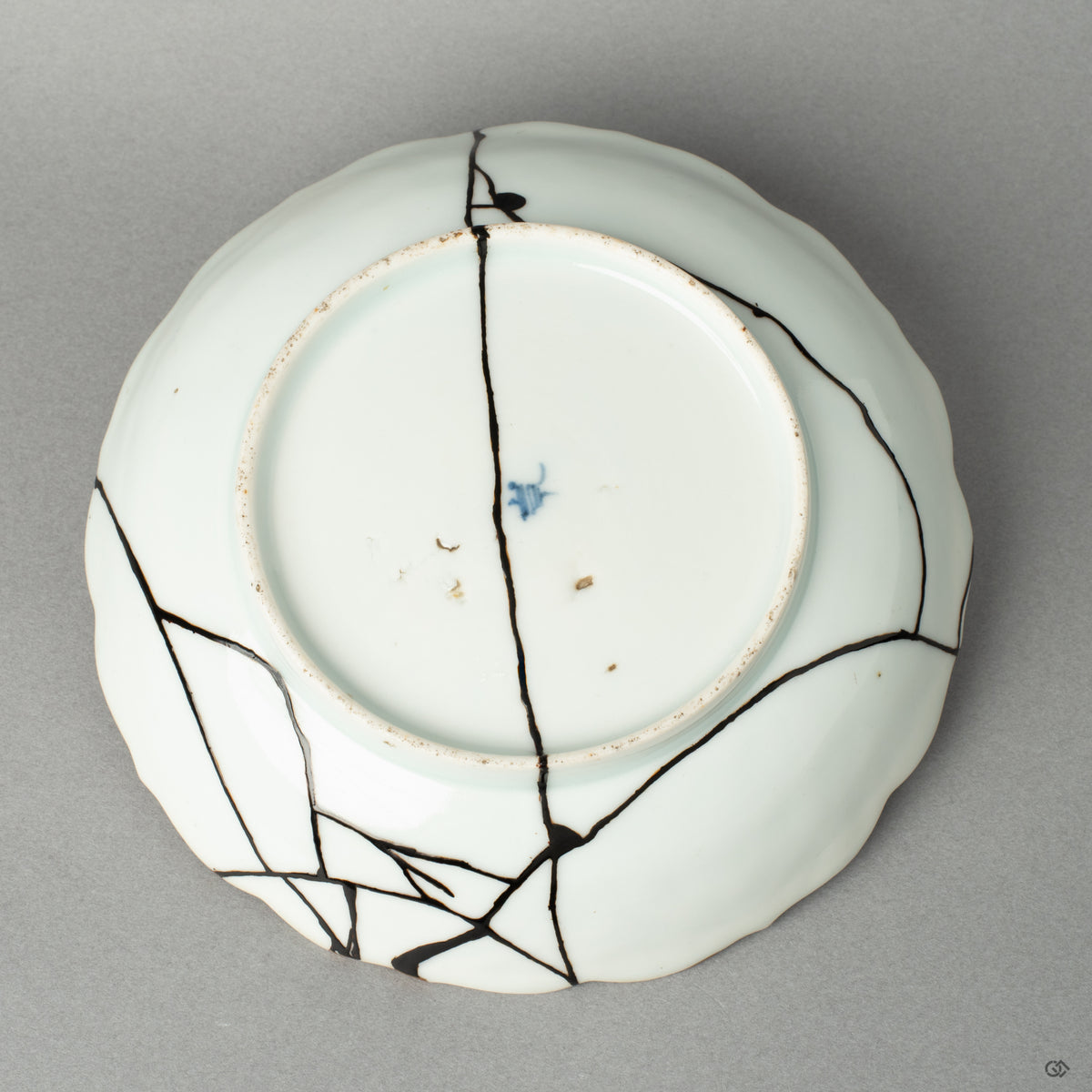 The antique base of a Ko-Imari bowl, its makers mark preserved alongside the subtle kintsugi mend, an act of honoring history.