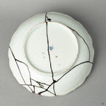 The antique base of a Ko-Imari bowl, its makers mark preserved alongside the subtle kintsugi mend, an act of honoring history.