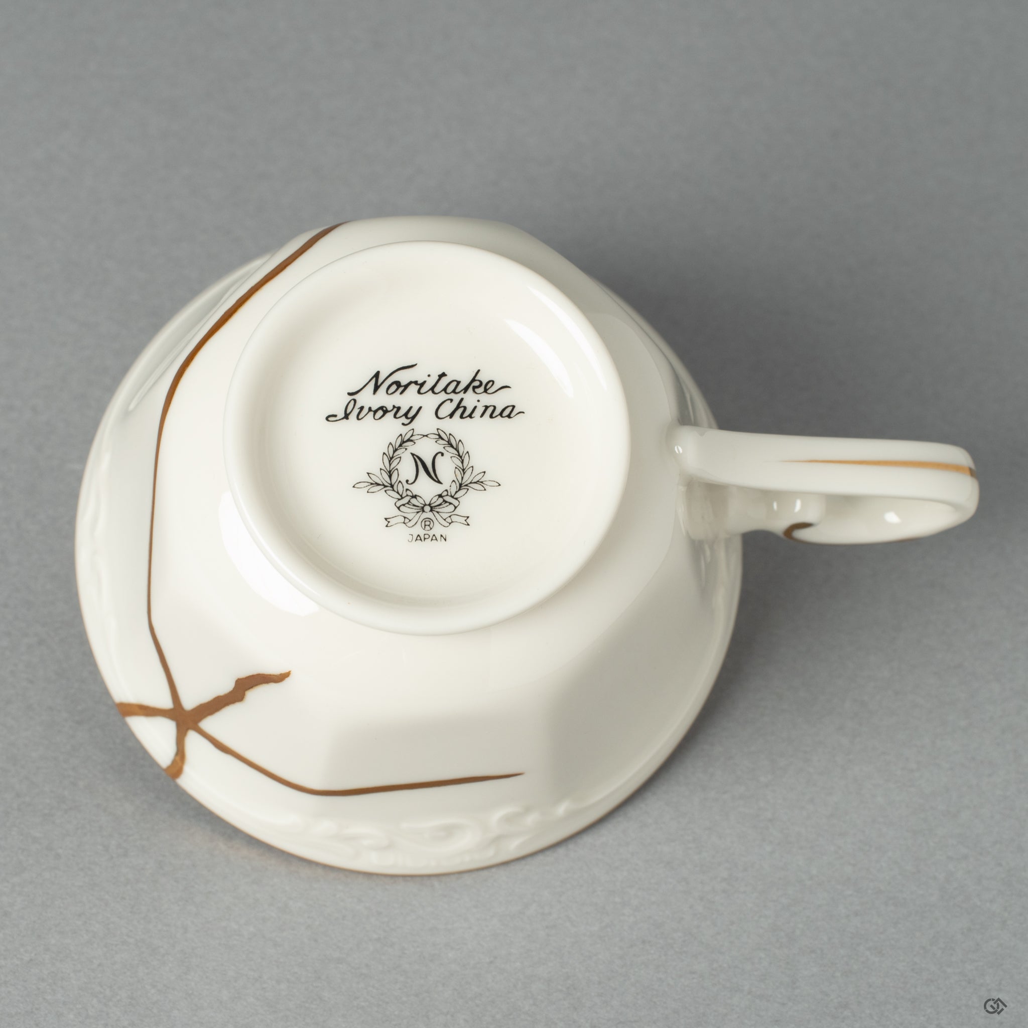A bottom view of an  authentic Japanese Kintsugi Cup repaired with 24K Gold artistry, showcasing its serene form and the beauty of imperfection.