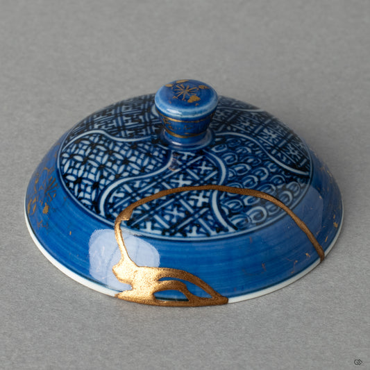A close-up of the kintsugi on the lid, where radiant gold meets quiet black lacquer, telling a profound story in every seam of its thoughtful healing.