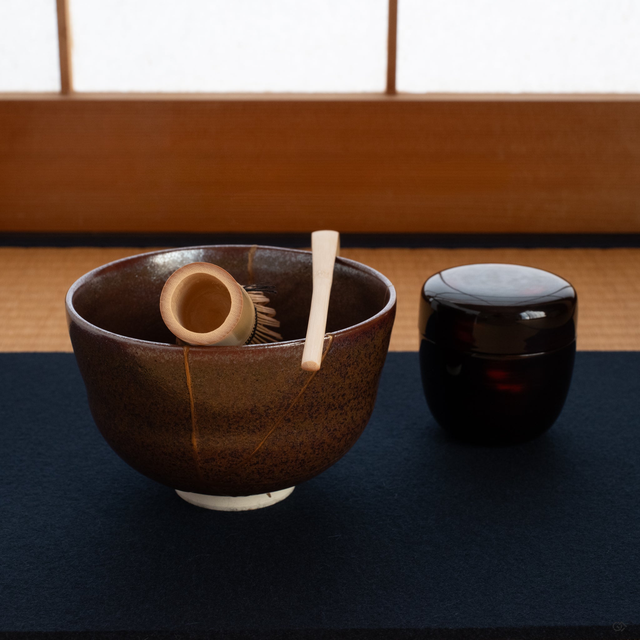 A Kyoto ware kintsugi matcha bowl resting on a tatami mat, its golden seam glowing, embodying the practice of art as meditation.