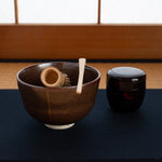 A Kyoto ware kintsugi matcha bowl resting on a tatami mat, its golden seam glowing, embodying the practice of art as meditation.