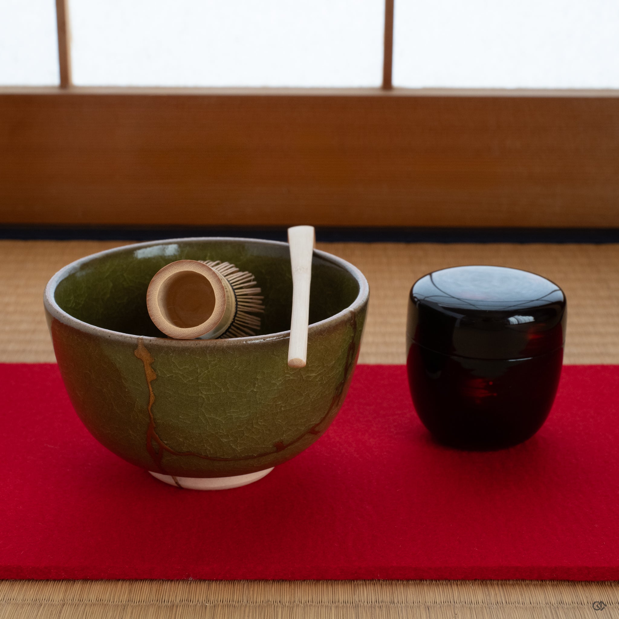 A Kyoto ware kintsugi matcha bowl resting on a tatami mat, its golden seam glowing, embodying the practice of art as meditation.