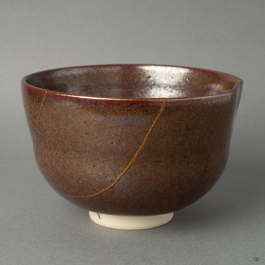 Side view of a kintsugi matcha bowl, the 24K gold seam tracing its form, a profound vision of resilience made beautiful.