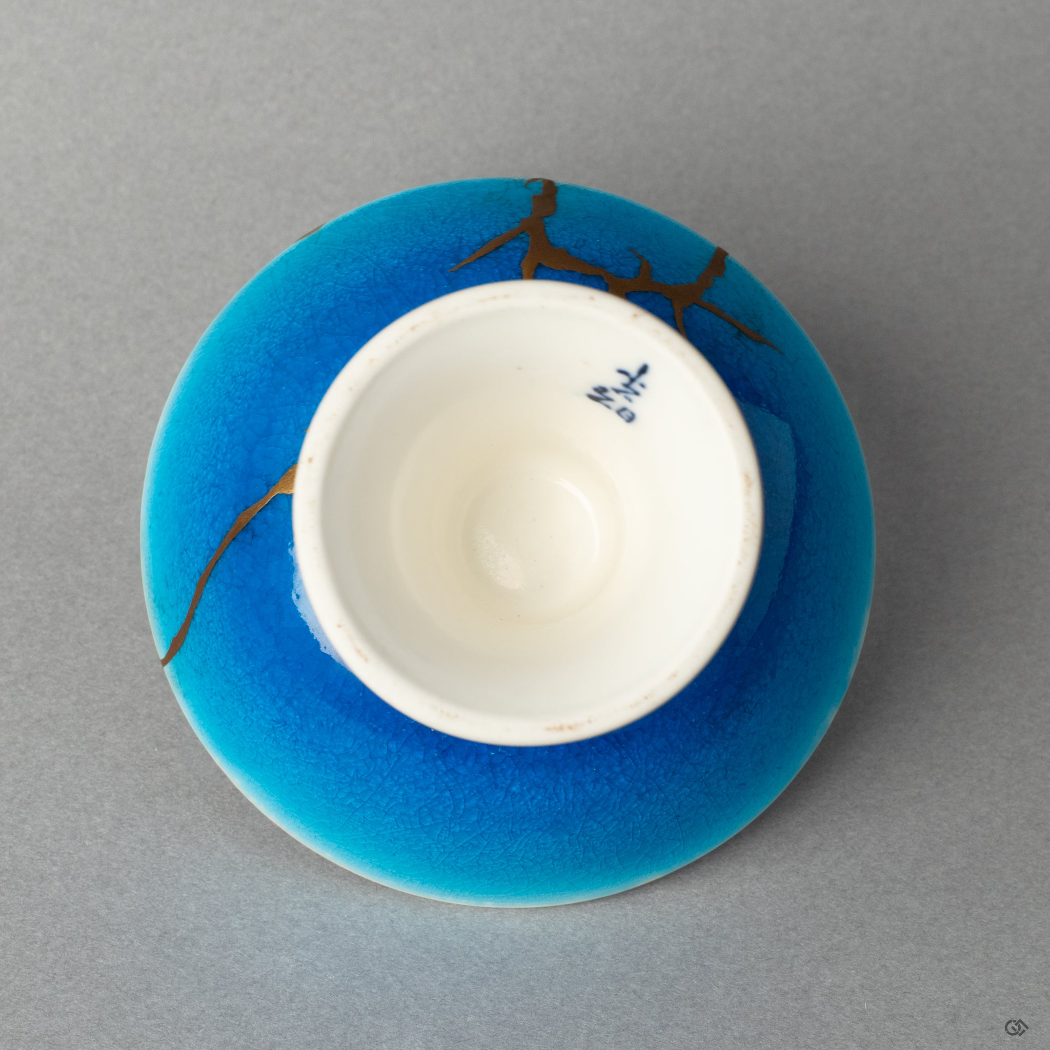 Bottom view of a kintsugi-repaired sake cup, a powerful investment in beauty and a treasured heirloom.