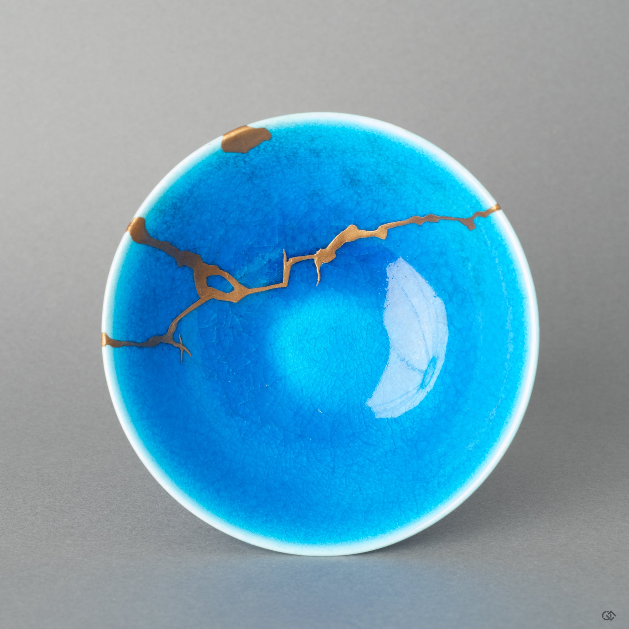 Top-down view of a kintsugi sake cup, its golden joinery tracing a history made visible—a tangible piece of Japanese philosophy.