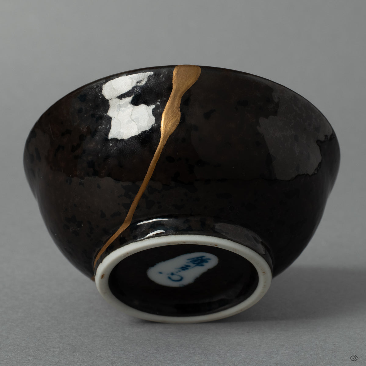 A macro view of a delicate maki-e branch growing from the golden seam, a beautiful expression of the art of urushi lacquer and renewal.