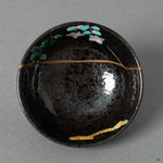 A top-down view into the Arita porcelain cup, its golden repair inviting a moment of contemplation before the cup is filled.